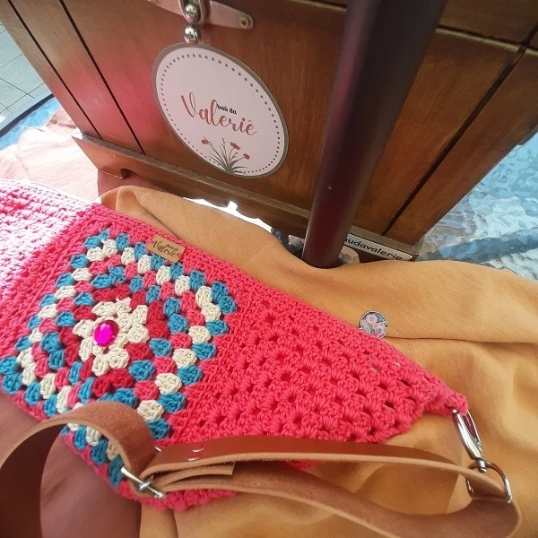 Pochete Rosa Brilho – Na cor rosa com detalhes azul claro, magenta  e creme. Aplicação em pedra acrílica   PORB